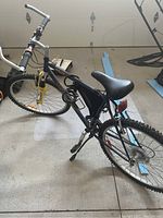 Full view of the bike showing frame, tires, seat, pedals, cable lock, and rear reflector.