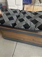 Close-up of the custom cushion with black and white geometric pattern placed on the cedar deck box bench.