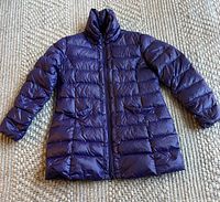Image of the full purple down jacket laid flat to show design and shape.