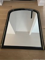 Full view of the black lacquer arched mirror showing overall design and condition.
