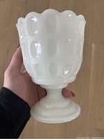 Front side view of the white hobnail milk glass dish showing scalloped edge and pedestal base.