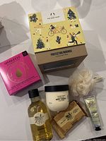 The Body Shop Protecting Moringa Little Gift Box with yellow festive box and all contents displayed including Moringa body yogurt, shower gel, soap, Spongelle body wash sponge, and cream bath loofah.