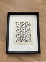 Framed art print of Fishy Fleet showing overall piece with black frame on wooden floor.