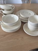 Full set arranged on table showing stacked cups, saucers, and plates illustrating size and design cohesiveness.