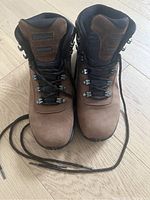 Top-down and front view of brown and black women's hiking boots with laces untied, showing the design and condition of the boots.