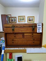 Front view of antique wooden dental box with metal clasps and drawer knobs