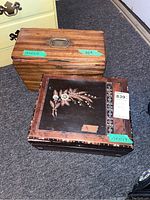 Two antique wood writing boxes side-by-side; one with an inlaid floral mother of pearl design, the other with a plain wood finish showing grain and a metal handle on the top.