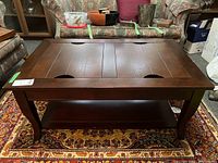 Front angle showing rectangular dark stained coffee table with inset trays and bottom shelf.