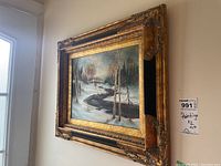Frontal view of a framed painting showing a winter river landscape