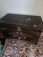 Front view of wooden chest showing latch and inlay design.