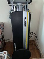 Inclined bench padded surface with Total Gym logo and yellow/silver stripes on black