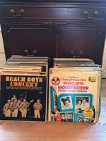 Two stacks of vinyl LP records featuring Beach Boys Concert and Disney Mickey Mouse Club Song Hits album covers featured prominently.