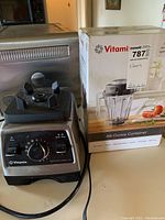 Full view of Vitamix Professional Series 750 blender base next to boxed 48-ounce container