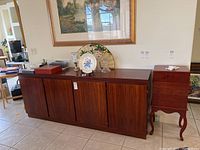 Front view of four-door wooden buffet with decorative items on top.