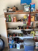 Six shelves with assorted tools, cleaning chemicals, brushes, gardening tools, and blue trash can