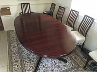 Oval table top view showing rosewood-grain finish