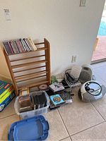 Overview of lot including Sony CD/cassette player, mixed CDs, CD stand, Pelonis heater, and cables.