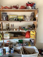 Six shelves holding assorted tools, extension cords, chemicals, lead weights, and a tub with tools.
