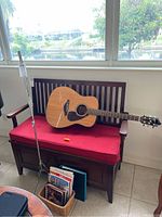 Full setup showing guitar on bench, music stand extended, basket of books on floor