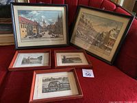 Five framed art prints on red surface, various sizes, detailed cityscapes and old architecture.