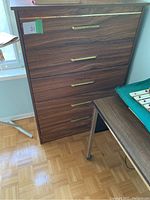 Front view of five-drawer dresser with woodgrain and gold handles, showing condition and dimensions.