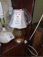 Amber glass lamp with pleated shade and price tag visible on shade