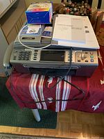The full view of the Brother MFC-685CW multifunction machine on a table with user manuals and ink cartridges on top.