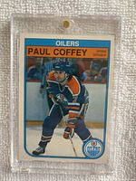 Front of 1982-83 O-Pee-Chee #101 Paul Coffey hockey card showing player image, team name Oilers, and position Defense.