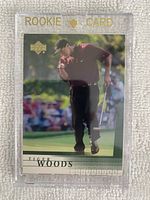Front of 2001 Upper Deck #1 Tiger Woods rookie card in protective magnetic holder, showing Tiger Woods in action on the golf course, with 'ROOKIE CARD' gold embossed at top.