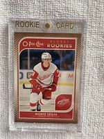Front view of the 2021-22 O-Pee-Chee Glossy Bronze Rookie Card featuring Moritz Seider in Detroit Red Wings uniform, showing player image and card details.