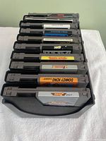 Top view showing all 10 Nintendo NES game cartridges stored in a black plastic game holder rack.