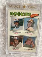 Front side of 1977 Topps #473 Rookie Outfielders card displaying photos of Andre Dawson, Gene Richards, John Scott and Denny Walling in magnetic rookie card holder.