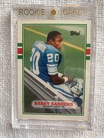Front of 1989 Topps Traded #83T Barry Sanders Rookie Card showing player in Detroit Lions uniform in a magnetic rookie card holder