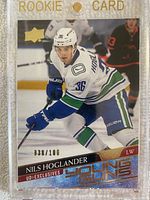 Front of the Nils Hoglander Young Guns rookie card with holographic foil and numbering 036/100, inside a clear magnetic rookie card holder.