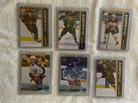 Front view of six rookie hockey cards in protective top loaders, laid on white textured fabric. Cards show players Jimmy Vesey, Oliver Bjorkstrand, Lane Pederson, Jack Ahcan, Olle Alsing and Jacob Peterson.