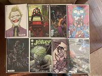 Full lot of eight comics with different Joker variant covers displayed in sealed protective sleeves.
