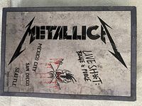 Closed metal box cover with Metallica logo and live tour locations printed