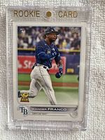 Front view of 2022 Topps #215 Wander Franco rookie baseball card in clear magnetic rookie card holder showing action pose of player in Tampa Bay Rays uniform.