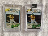 Front of both Rickey Henderson cards in protective cases showing 1980 Topps RC with rough edge and 2020 Project 2020 card with artistic black outlines.