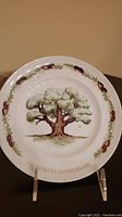 Clear photo of ceramic plate featuring a large oak tree in the center and decorative acorn vine border. The text 'FIFTH ANNIVERSARY' is visible at the bottom.