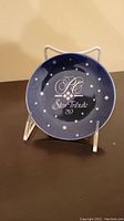 Blue 1989 Star Tribute collector plate with star motifs displayed on a stand