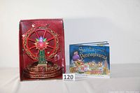 Ferris wheel and book displayed side by side with lot number 120 visible.