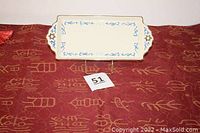Ceramic rectangular Hanukkah platter on red tablecloth showing overall shape and design.
