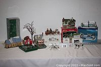 Overview of all ten buildings, accessories, and two light strings on white cloth