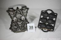 Photo of the two cast iron muffin molds side by side: a Christmas tree mold and a snowmen mold