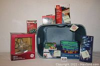 Multiple new boxed Christmas light sets and a star with 15 lights displayed inside and around a plastic bin