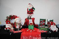Photo showing the group of items including standing Santa, Santa doorknob hangers, wreath, ornaments, and Santa shirt