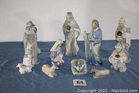 10-piece blue and white porcelain Nativity set with traditional figures and animals arranged on a blue cloth background