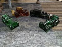 Four Avon collectible glass bottles shaped as vintage cars and a train displayed on a carpeted floor.