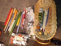Wide view showing assortment of taper candles, packs of tealight candles in aluminum holders, several votive candles, and wicker basket